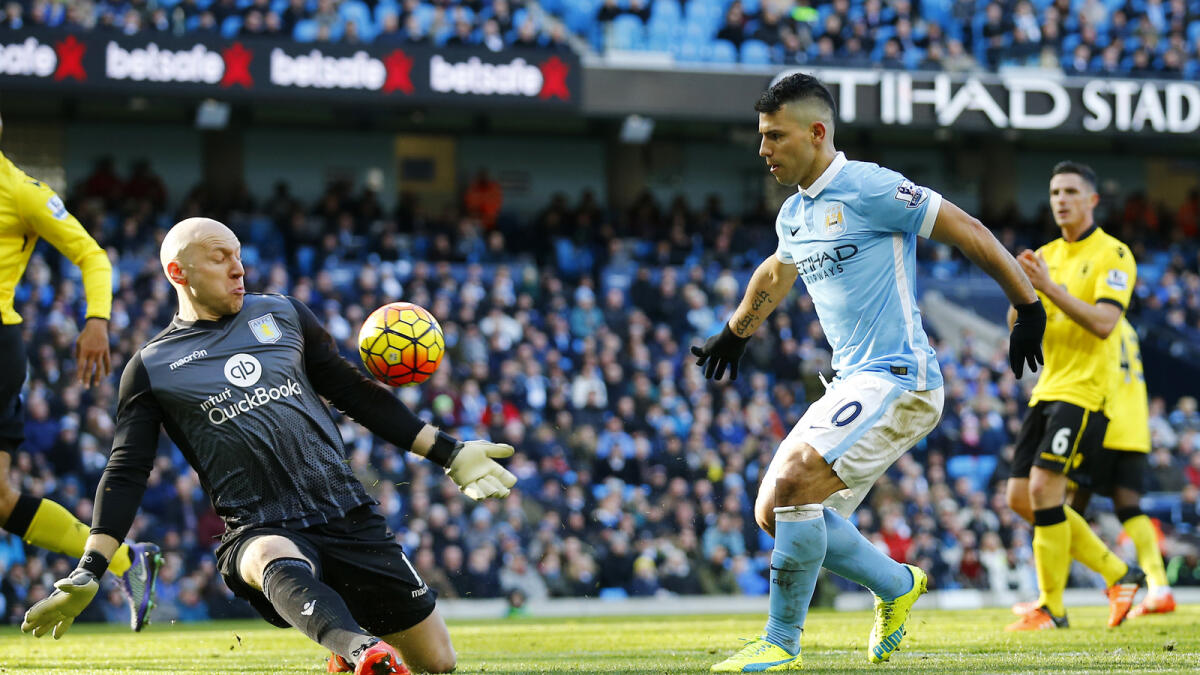Manchester City’s Sergio Aguero (right) chips the ball over Aston Villa’s goalkeeper Brad Guzan.  