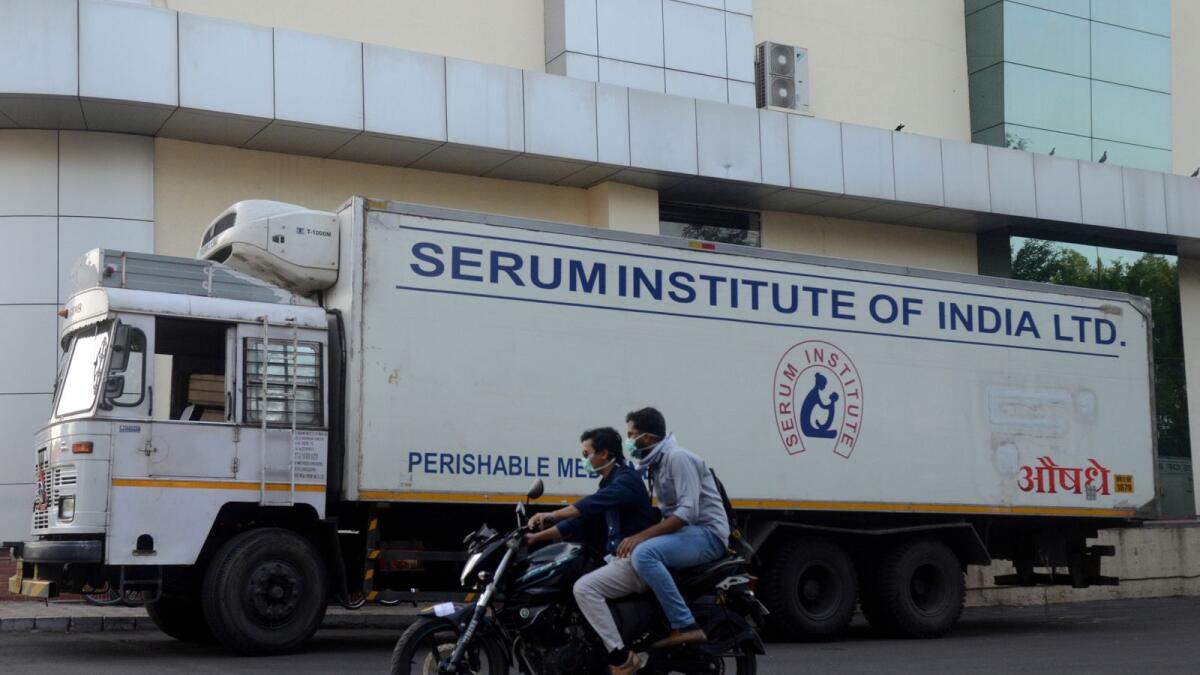Men ride on a motorbike past a supply truck of India's Serum Institute, the world's largest maker of vaccines, which is working on a vaccine against the coronavirus disease (COVID-19) in Pune, India, May 18, 2020.