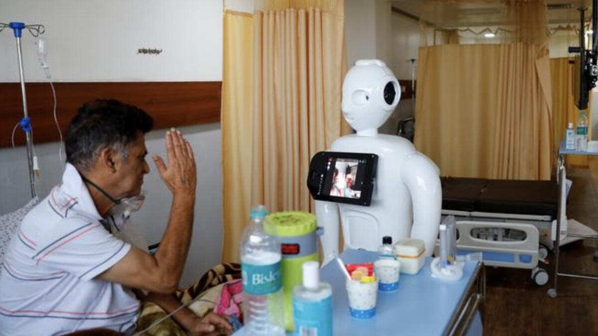 A patient suffering from the coronavirus speaks to his family members using a robot named 'Mitra' at the ICU of the Yatharth Super Speciality Hospital in Noida, on the outskirts of New Delhi, India.