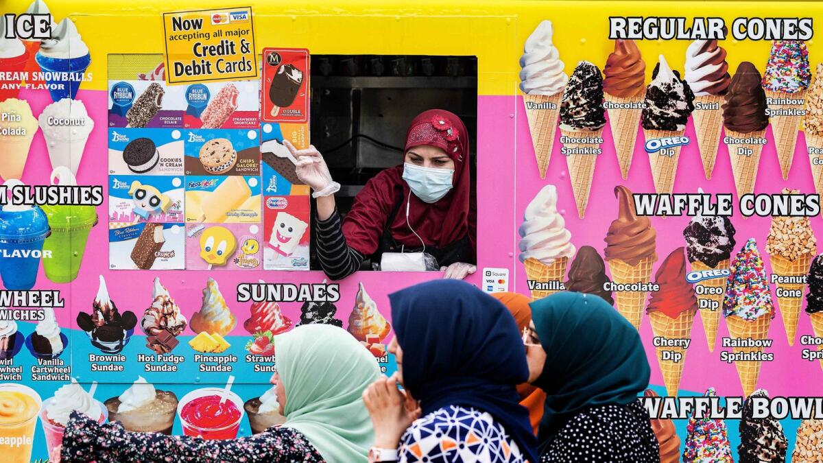 Four girls in hijabs buy ice cream from a food truck in Washington, DC, on Friday.