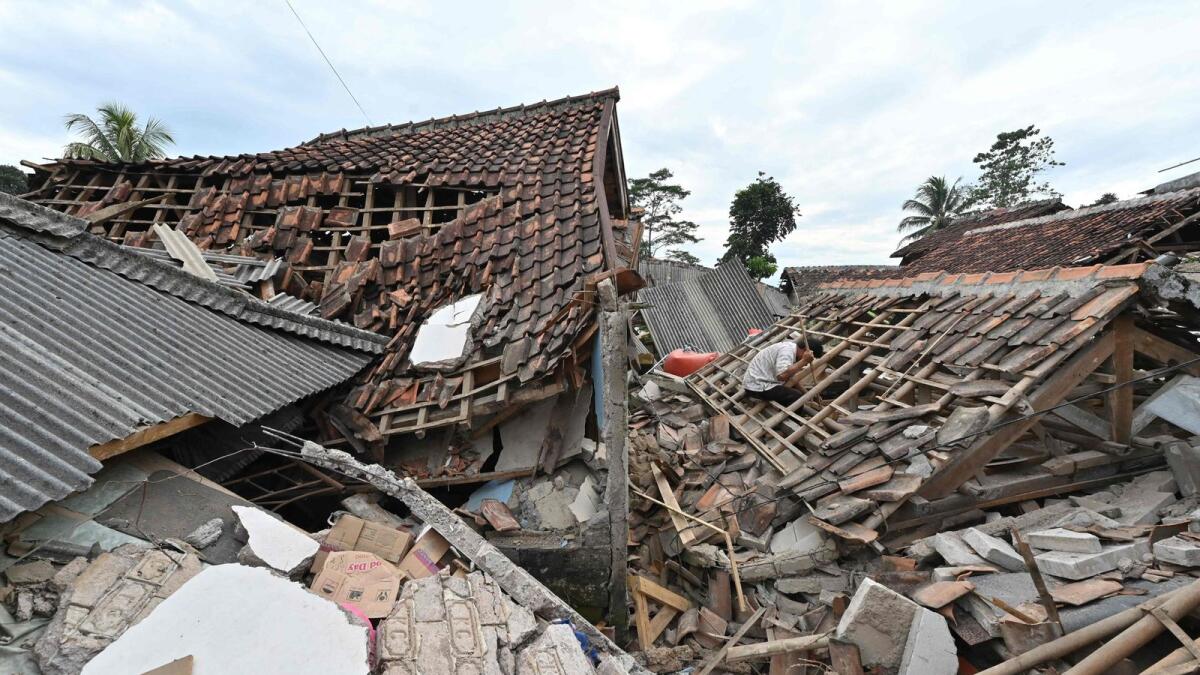 A man sifts through the rubble of a collapsed house in Cugenang, Cianjur on November 23, 2022, following a 5.6-magnitude earthquake on November 21. Photo: AFP