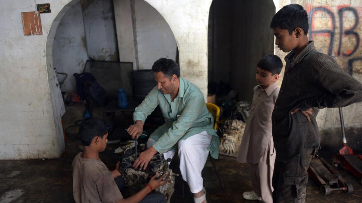 Pakistani blind mechanic Asif Patel working at his workshop in Karachi.