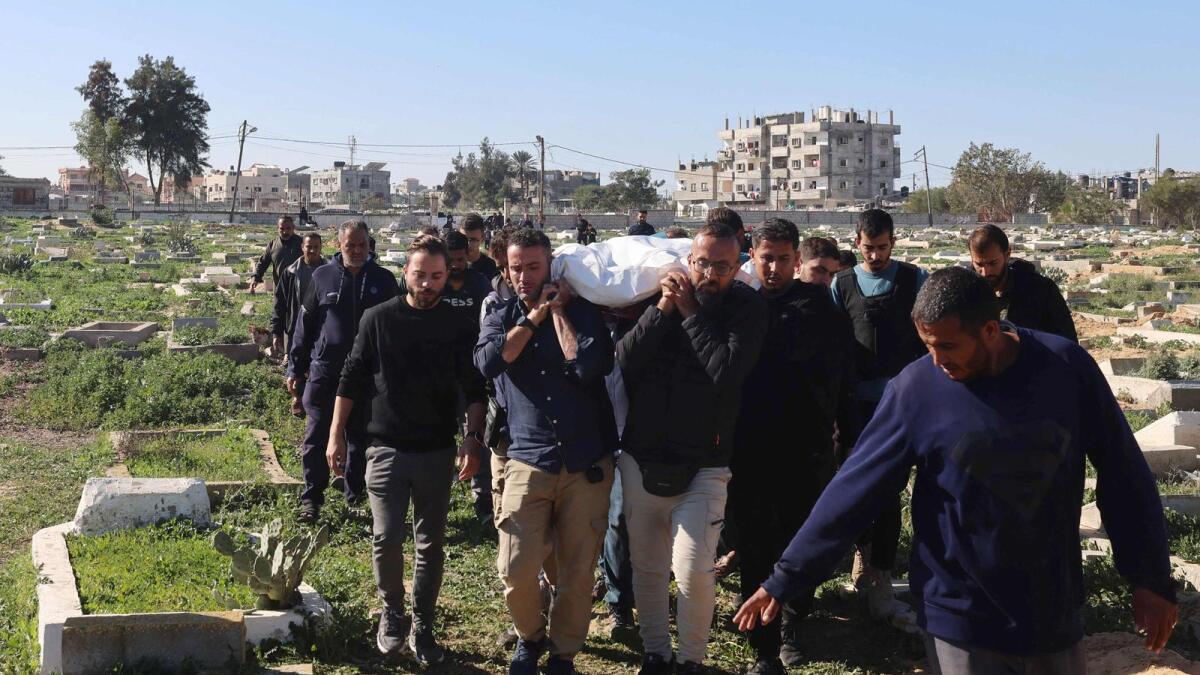 Fellow journalists carry the body of Hamza Wael Dahdouh, a journalist with Al Jazeera television network, who was killed in a reported Israeli airstrike during his funeral in Rafah in the Gaza Strip on January 7. — AFP file