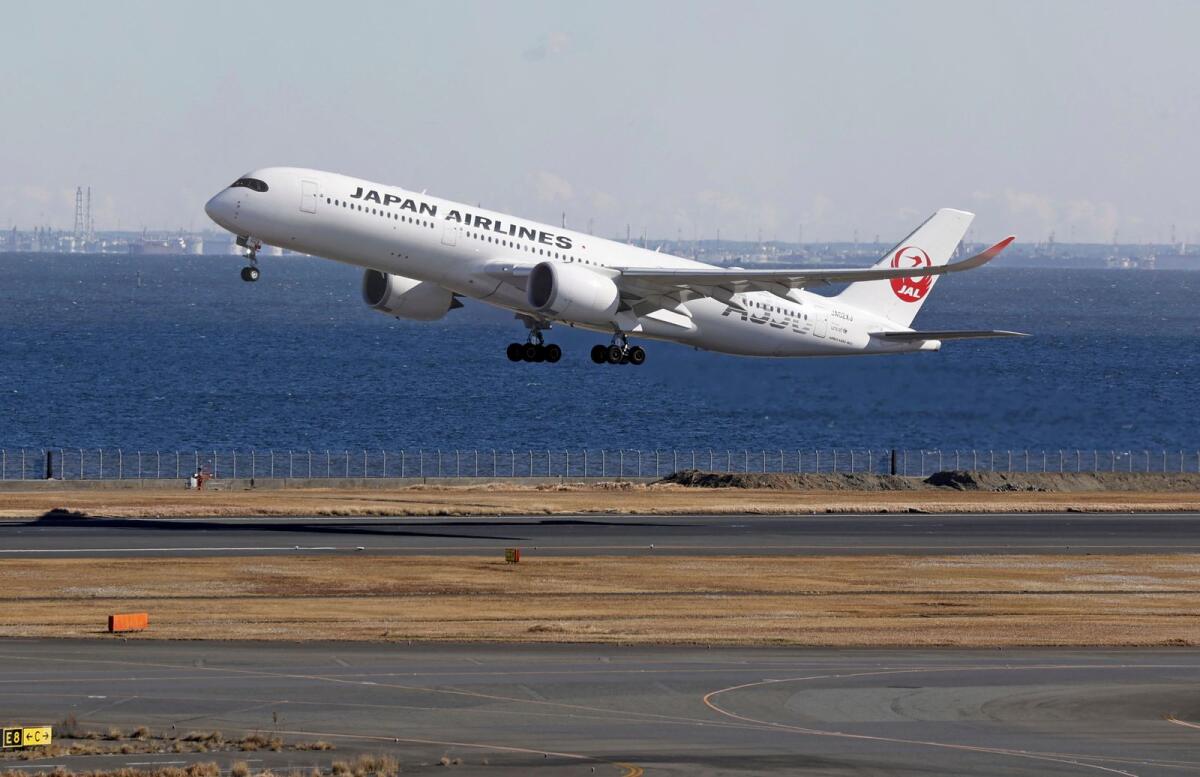 A Japan Airlines plane takes off from the runway where a plane collision took place, at Haneda airport in Tokyo on Monday. — AP