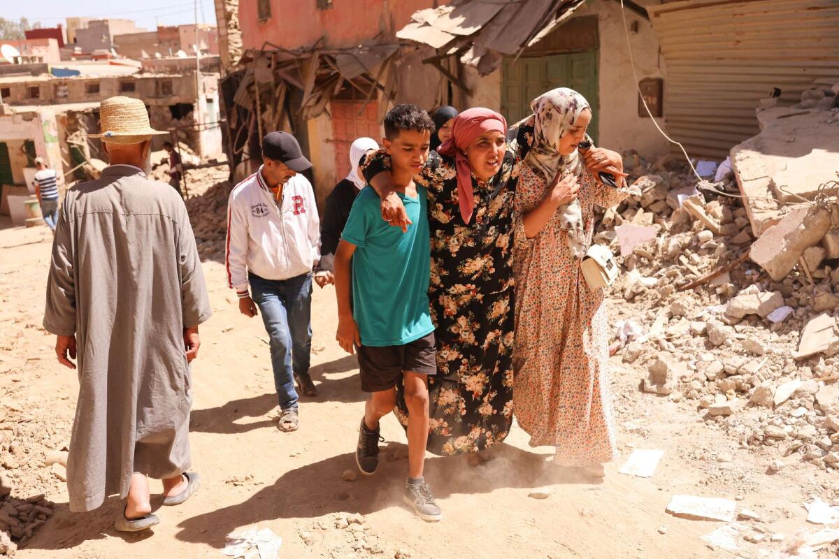 People walk next to a damaged building, in the aftermath of a deadly earthquake, in Amizmiz, Morocco, September 10, 2023. Photo: Reuters