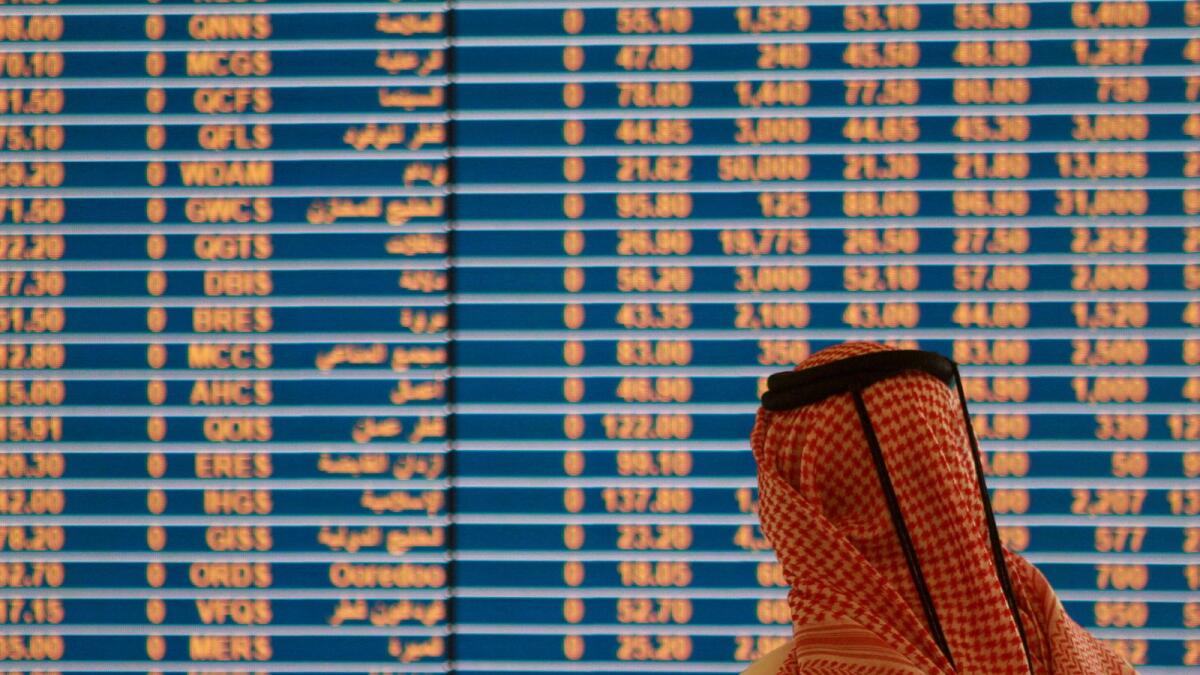 A trader watches an electronic share price display at the Doha Stock Exchange in Doha. — Reuters file photo