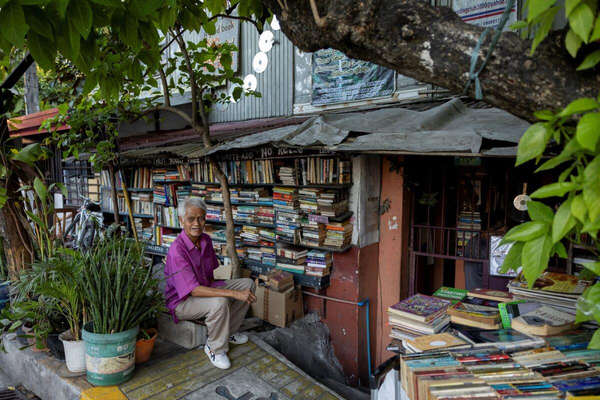 Hernando Guanlao, also known as Mang Nanie, 72, poses in front of his communal library at his home in Makati, Metro Manila, Philippines, February 7, 2024. — Reuters