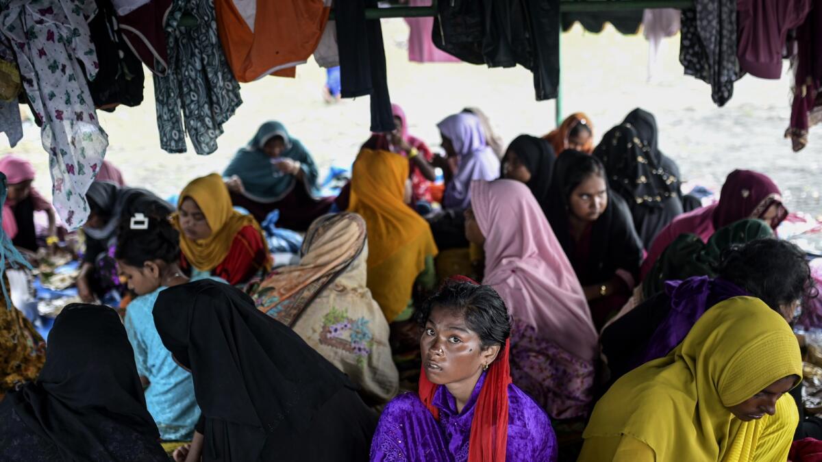 Ethnic Rohingya women take shelter under a tent near a beach in Pidie. — AP