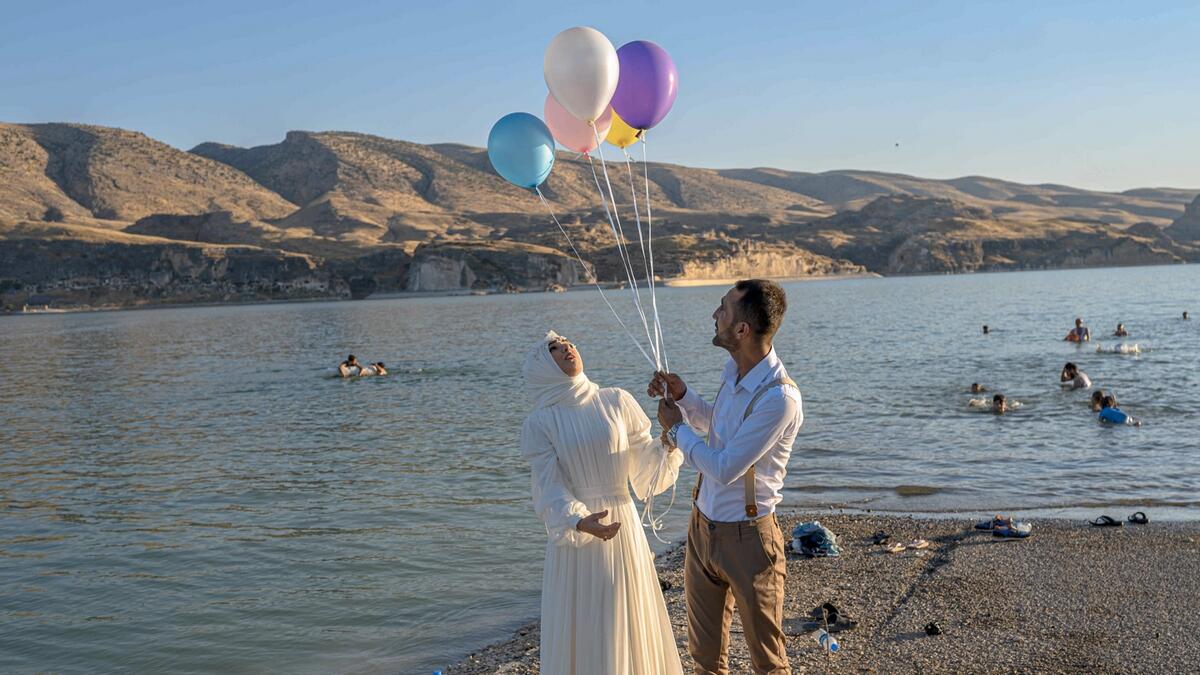 A newly married couple next to the the Ilosu Dam separating the newly constructed Hasankeyf town from the remains of the ancient town of the same name and its archaeological sites which were flooded as part of the Ilo~su Dam project located along the Tigris River in the Batman Province in southeastern Turkey.  Photo: AFP&lt;br&gt;(Research: Mohammad Thanweeruddin/Khaleej Times)