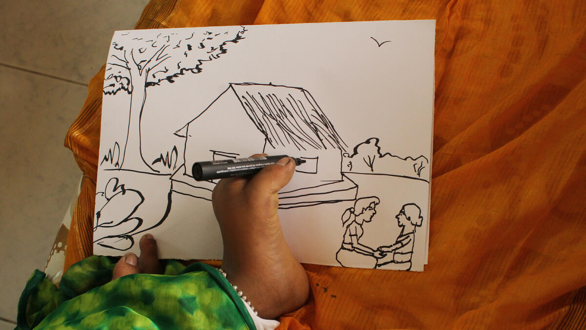 Kanmony Sasi, 15, draws a special piece using her feet for Khaleej Times during her stay in Dubai.