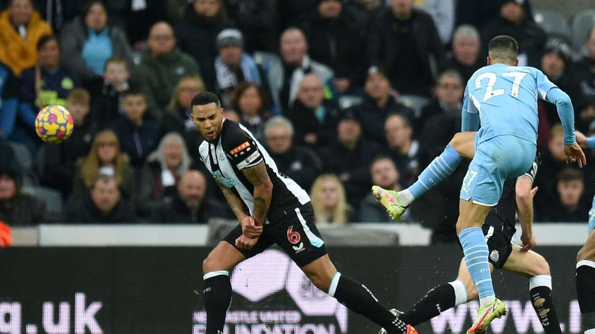 Manchester City defender Joao Cancelo (centre) shoots to score their second goal against Newcastle United. (AFP)