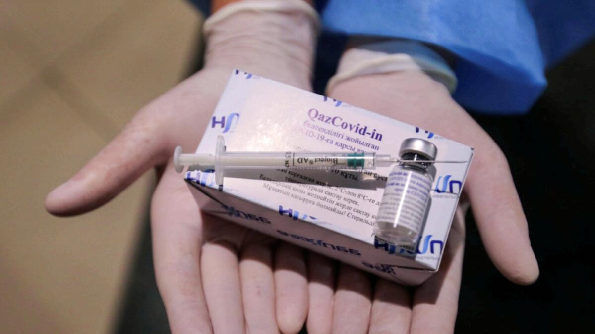 A medical worker shows a a syringe and a box containing vials with the QazCovid-in vaccine in a vaccination centre located at a shopping and entertainment mall in Almaty. — Reuters