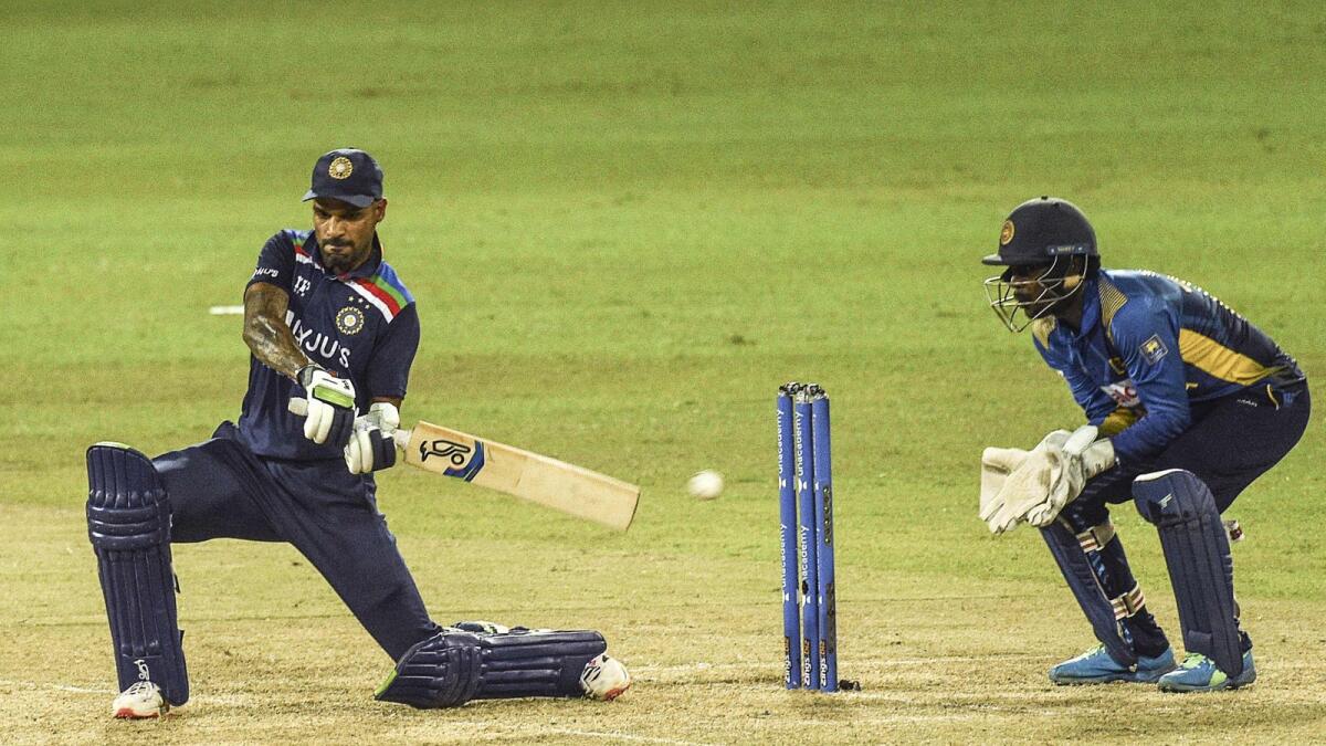 India's captain Shikhar Dhawan (left) plays a shot during the first ODI against Sri Lanka . — AFP