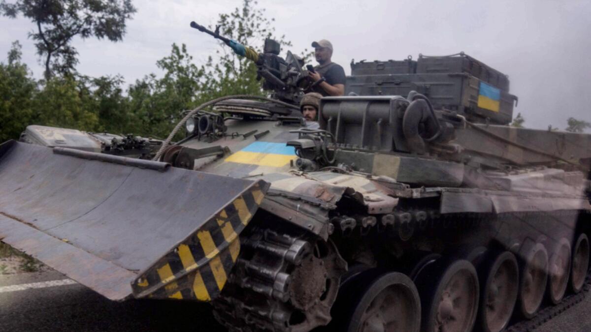 Ukrainian soldiers ride a tank on a road, in Stupochky, Donetsk region. — AP file