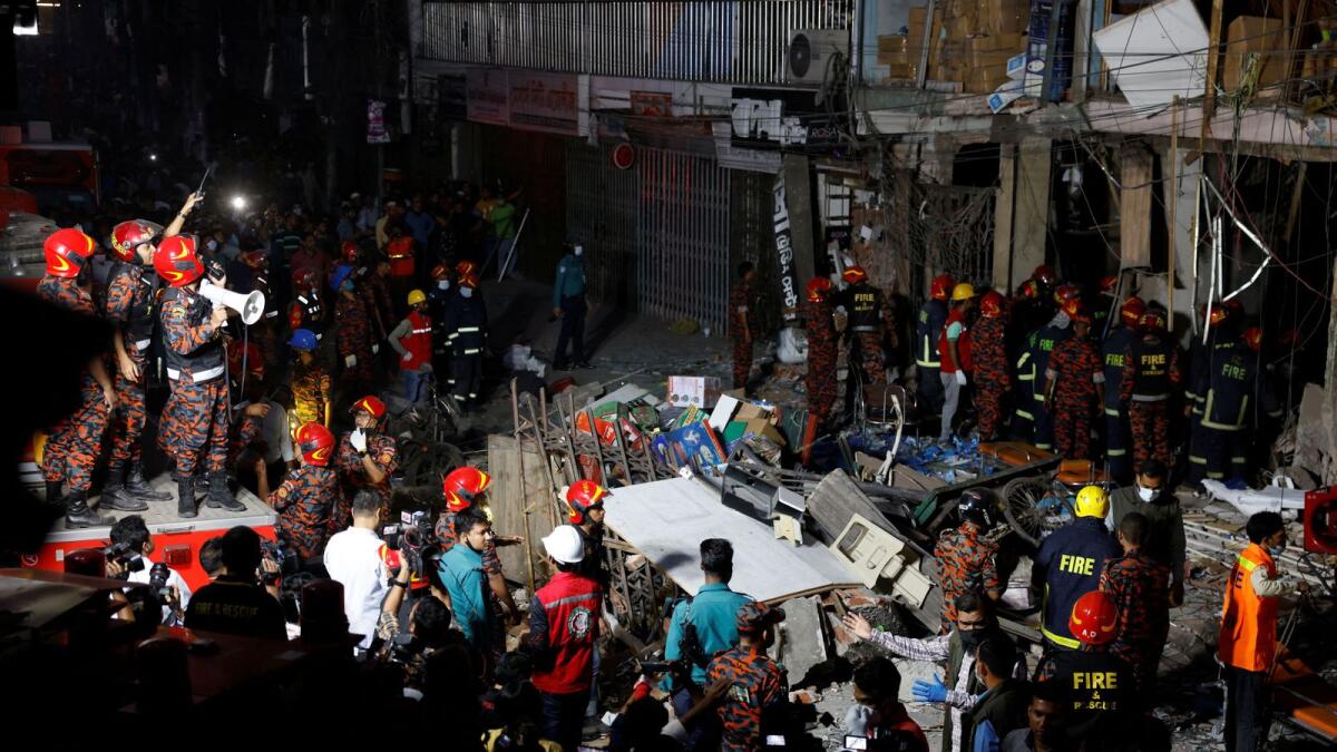 Firefighters and rescue workers are seen on the site of an explosion in a multi-storey building in Dhaka. — Reuters