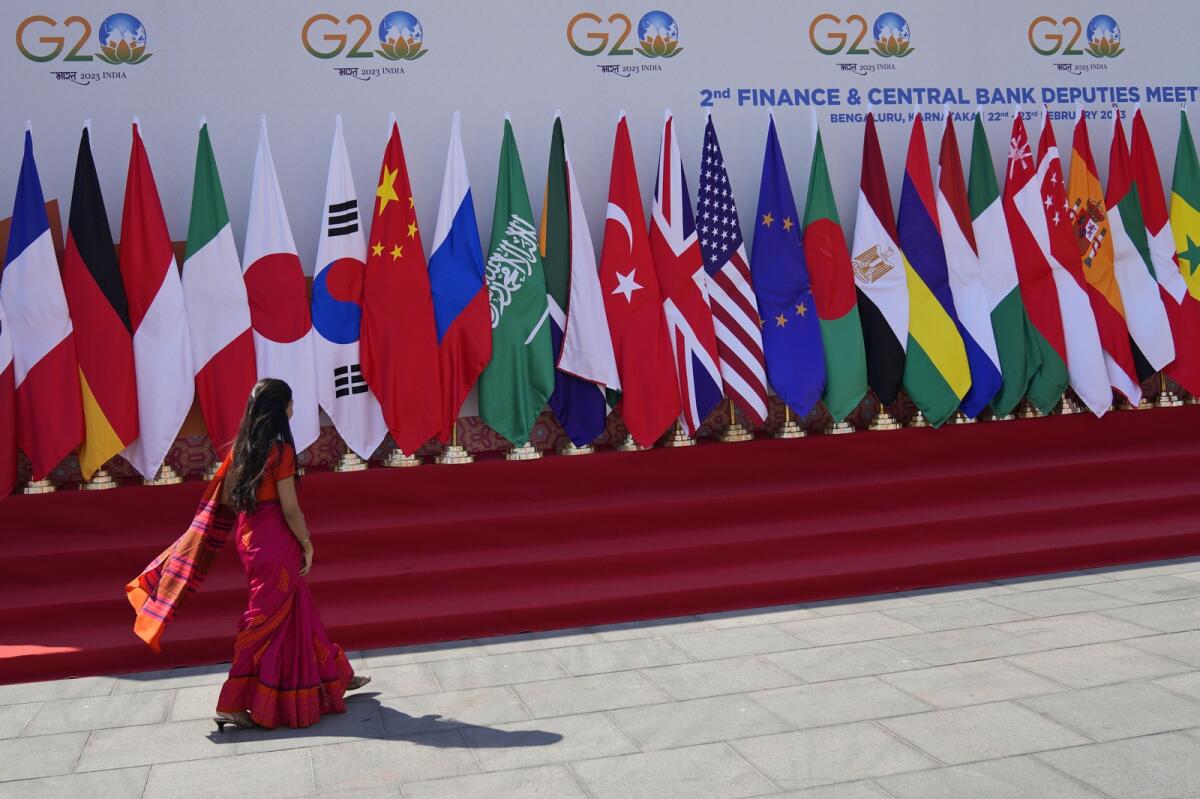 A delegate walks past a display of flags of participating countries at the venue of G-20 financial conclave on the outskirts of Bengaluru, India, on February 22, 2023. Photo: AP