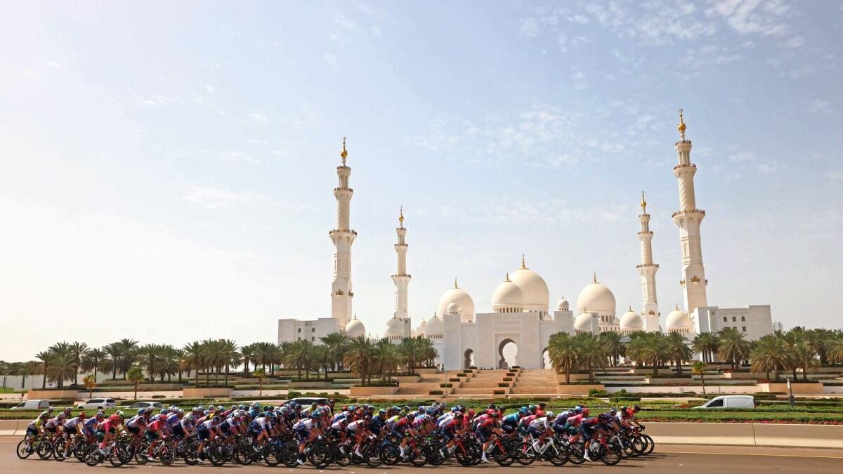 Keep the faith: The peloton rides across the Sheikh Zayed Grand Mosque during the second stage of the UAE Tour from Al Hudayriat island to Abu Dhabi Breakwater, on Monday. — AFP