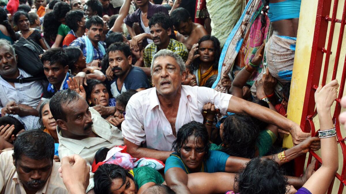 Indian devotees gather near the bodies of those killed after a stampede at a religious festival in Godavari in the Rajahmundry district some 200 kms north-east of Hyderabad on July 14, 2015.
