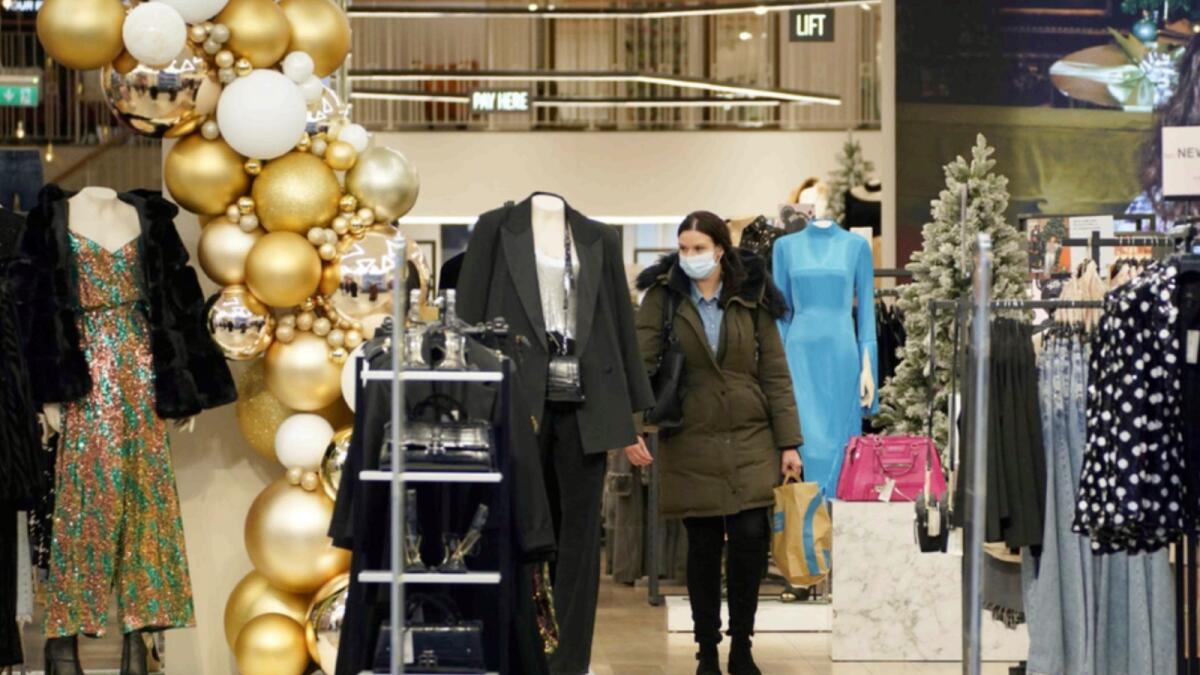 A woman wears a face mask inside a shop in Liverpool. — AP