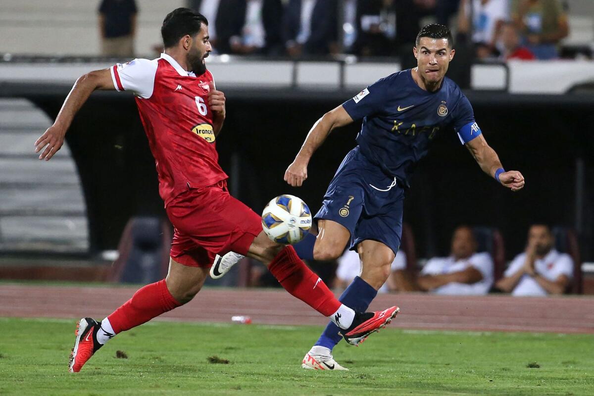 Al-Nassr's Cristiano Ronaldo vies for the ball with Persepolis' defender Hossein Kanaanizadegan. — AFP