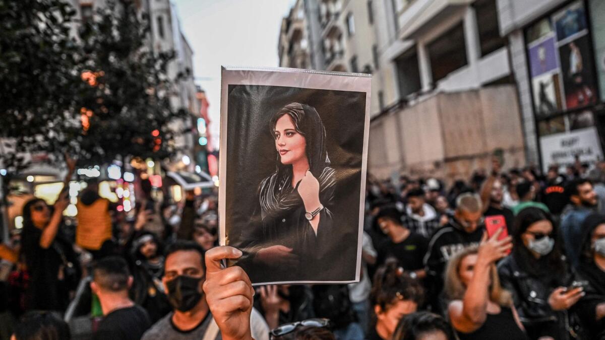 A protester holds a portrait of Mahsa Amini  during a demonstration in Istanbul. Amini, a young Iranian woman, died in morality police custody in Tehran last year. — AFP file