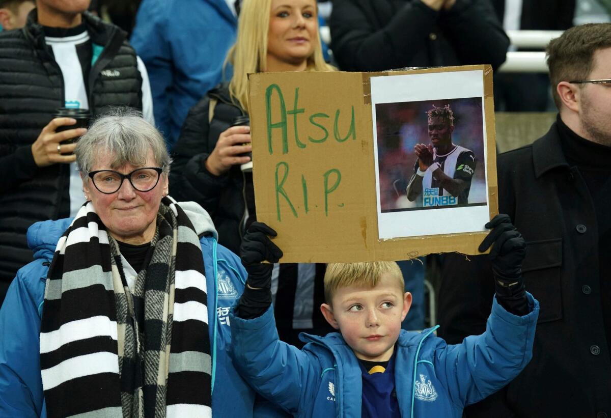 A Newcastle United fan holds up a sign in memory of Christian Atsu who has died following the devastating earthquake that hit Turkey, before the English Premier League match between Newcastle United and Liverpool at St. James' Park on Saturday. — AP