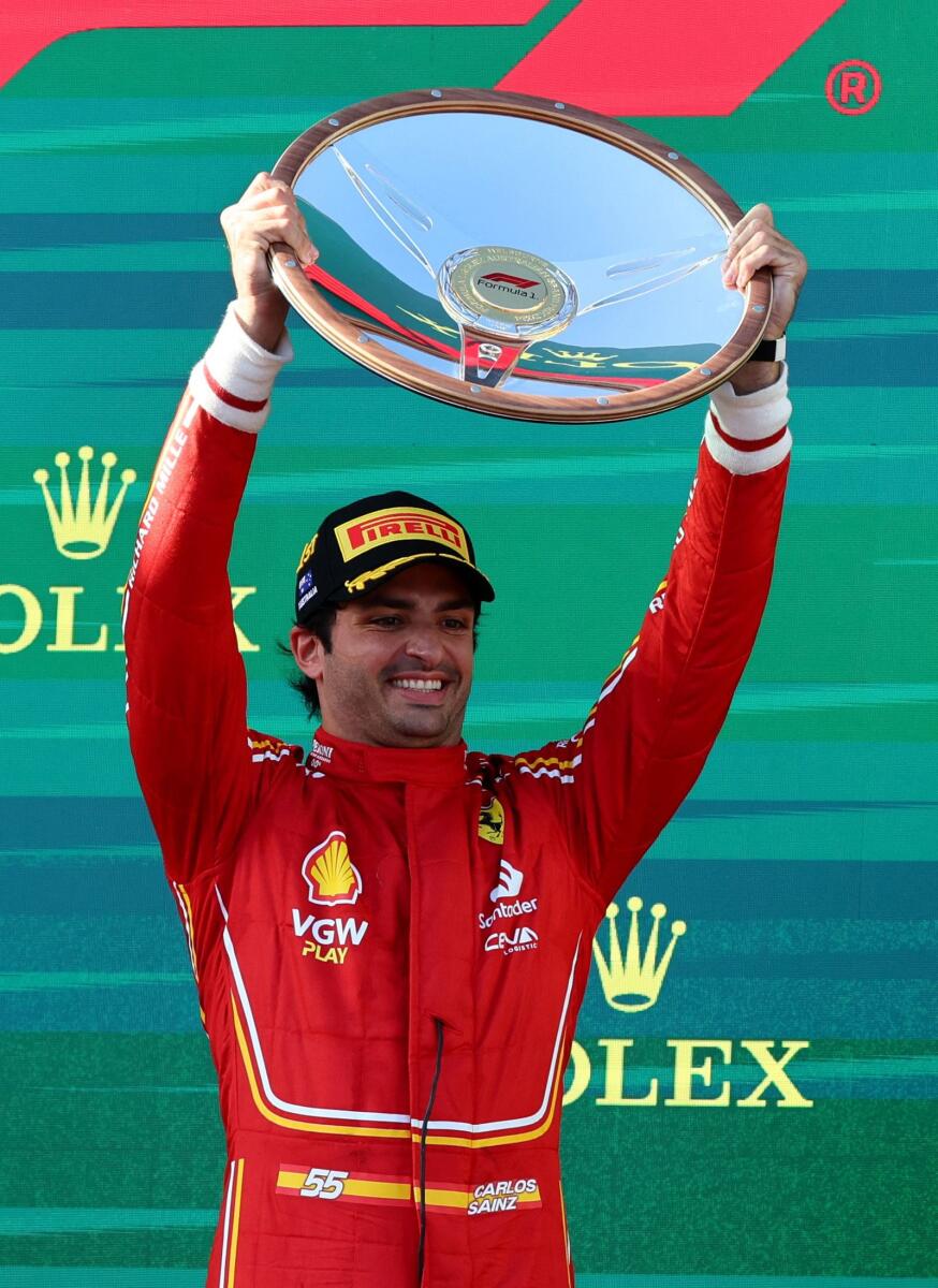 Ferrari's Carlos Sainz Jr. celebrates with the trophy on the podium. — Reuters