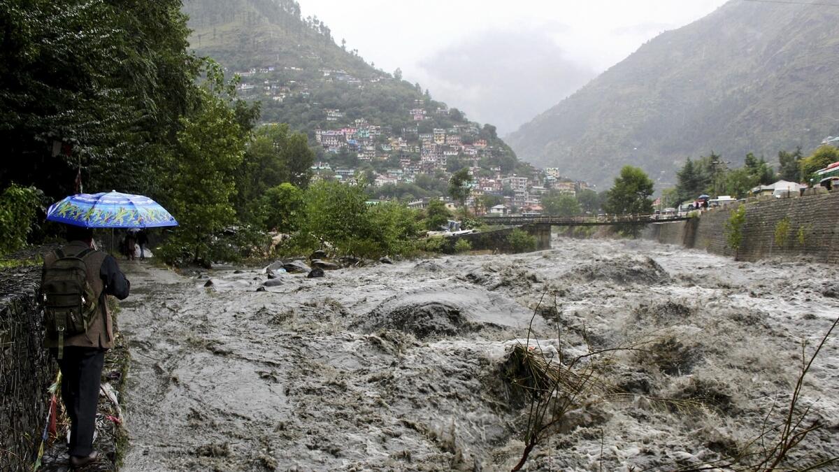 A man looks at a flooded Beas River following heavy rains in Kullu, Himachal Pradesh, India.-AP 
