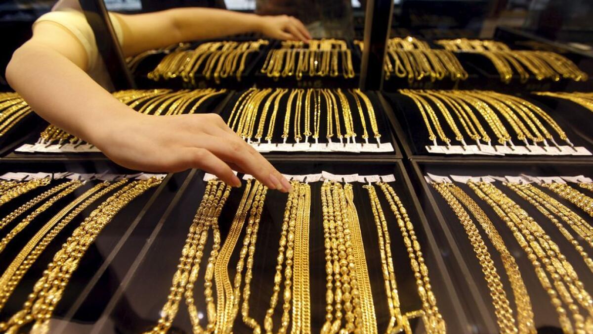 An employee arranges gold jewellery in the counter 