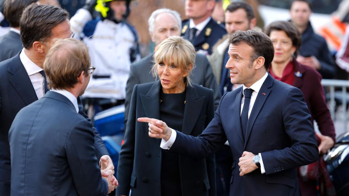 France's President Emmanuel Macron points towards Netherlands' Prime Minister Mark Rutte (L) as he arrives at the Rijskmuseum in Amsterdam with his wife Brigitte Macron on Wednesday.  -- AFP