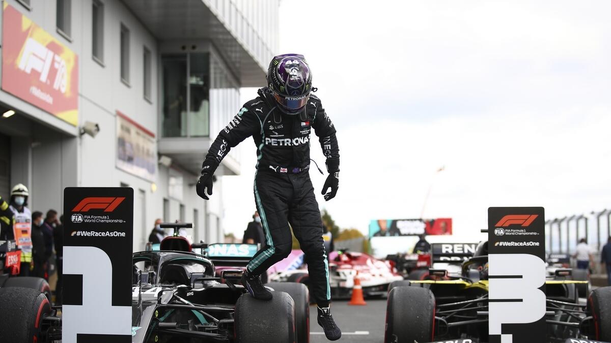Mercedes driver Lewis Hamilton of Britain jumps down from his car after winning the Eifel Formula One Grand Prix