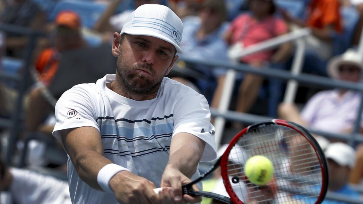 Mardy Fish hits a return to Feliciano Lopez during their match at the US Open. 