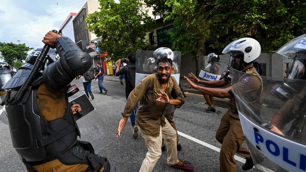 A Sri Lankan university student clashes with police during a demonstration in Colombo on Thursday. Police fired tear gas and water cannon on a small protest to break up the first demonstration since the crisis-hit island nation lifted a state of emergency.  — AFP
