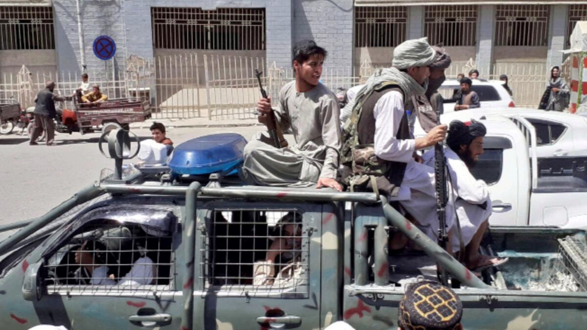 Taliban fighters are pictured in a vehicle of Afghan National Directorate of Security (NDS) on a street in Kandahar. — AFP