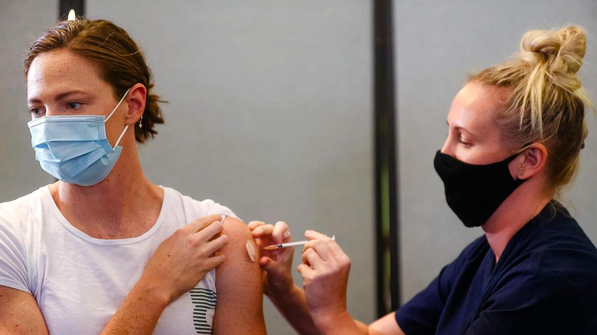 Three time Olympian Australian swimmer Cate Campbell (left) receives her dose of Pfizer/BioNTech vaccine against Covid-19 at the Queensland Sports and Athletics Centre in Brisbane on Monday.— AFP