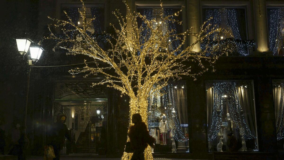 A woman walks past a New Year's decoration in central Moscow, Russia.