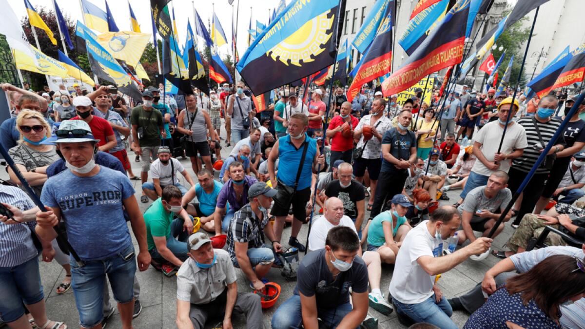 Miners bang their helmets as they make demands, including their salary debt repayment and reforms in the coal industry, in front of the building of a presidential administration in Kyiv, Ukraine. Photo: Reuters