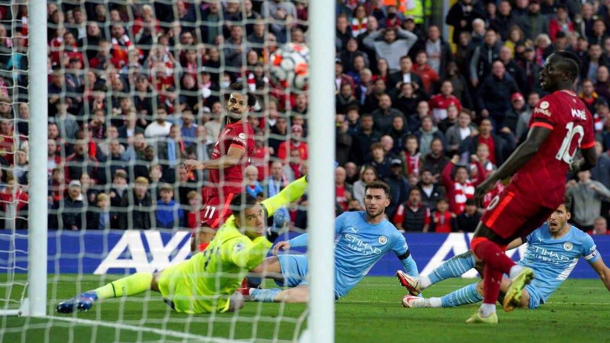Liverpool’s Mohamed Salah (left) scores against Manchester City at Anfield on Sunday. — AP