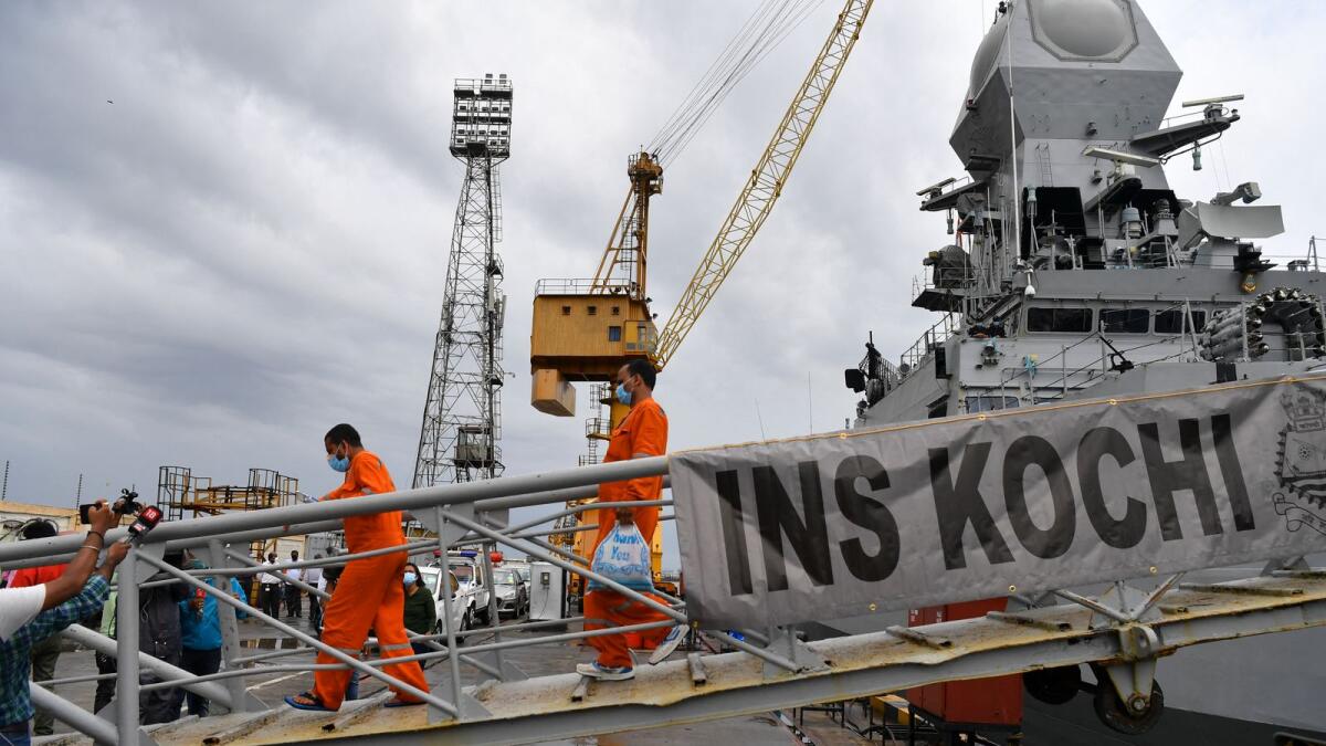 Rescued crew members from the sunken offshore barge P305 disembark the INS Kochi naval ship after arriving in Mumbai. Photo: AFP