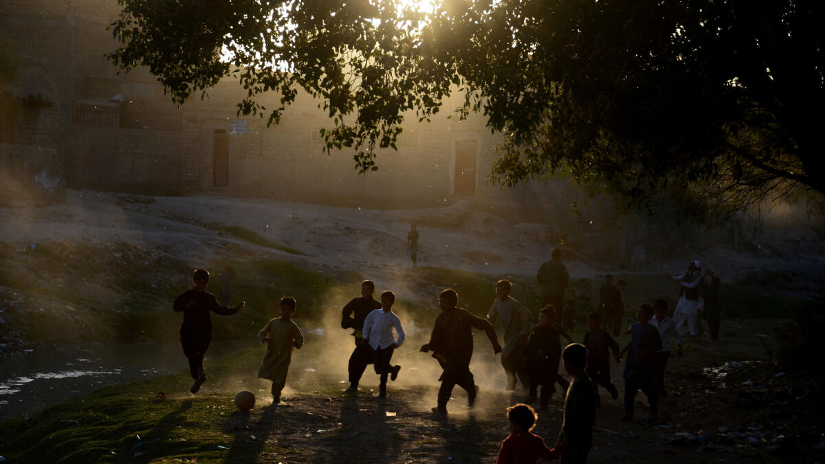 Afghan boys play football in a field in Herat. Football is a popular sport in the war-torn country.  AFP