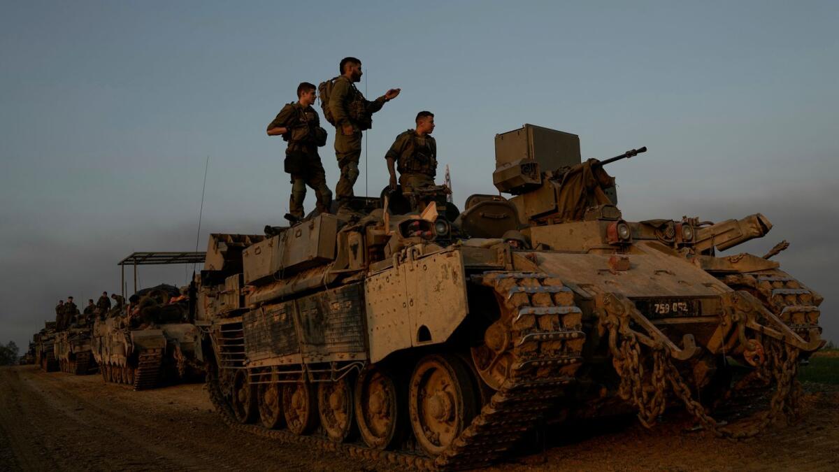 Israeli soldiers stand on top of armoured personnel carriers near the Israeli-Gaza border, in southern Israel on December 25. — Photo: AP