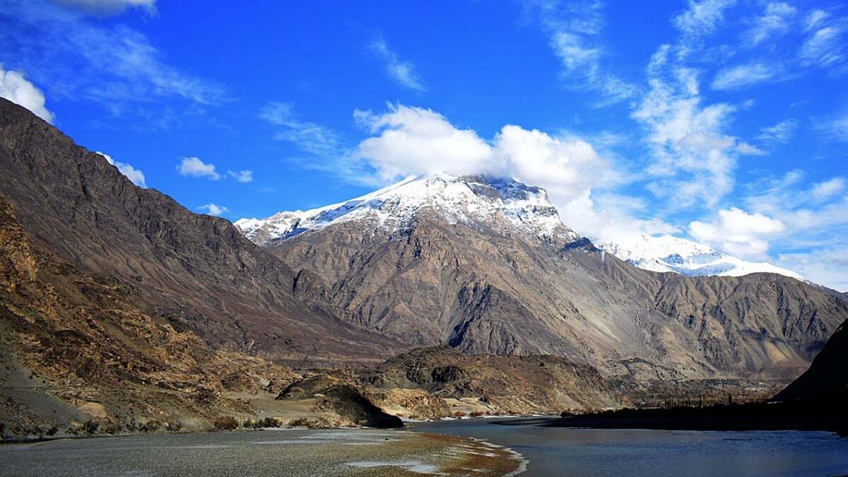 Clouds hovering over the snow covered mountains along the Indus river.
