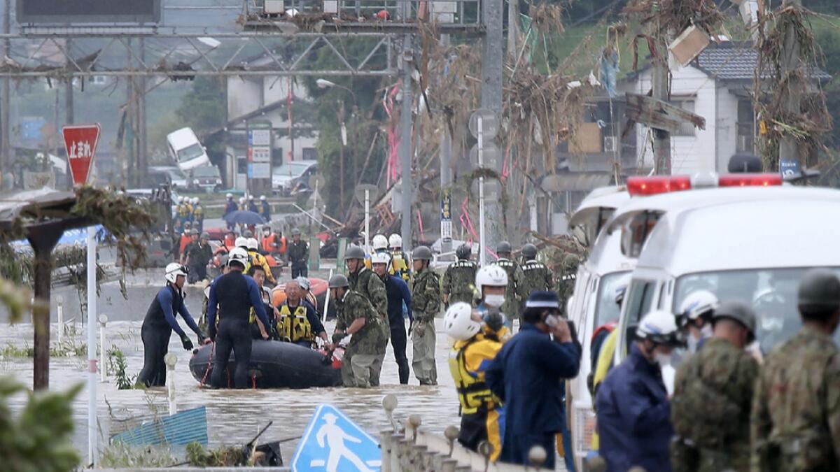 Residents are evacuated from flood-affected area by rubber boats in Kuma village, Kumamoto prefecture. At least 16 people are dead after torrential rain in Japan triggered massive floods and mudslides, local media said,  as rescue workers sift through debris in search of a dozen missing.  Photo: AFP(Research done by Fakhar Ul Islam/KT)