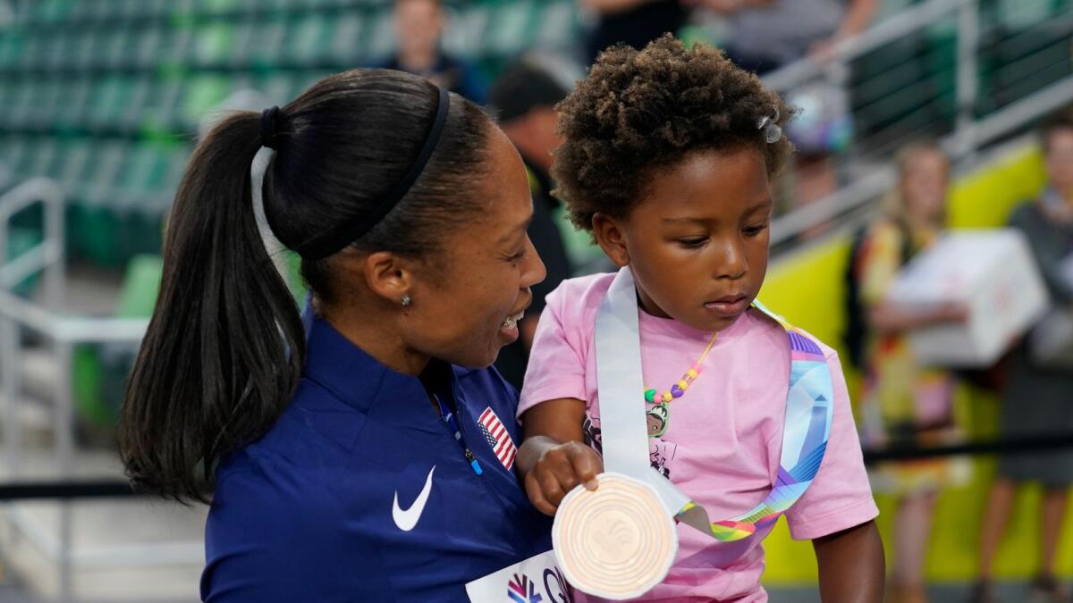 Allyson Felix gives her daughter Camryn her bronze medal. — AP