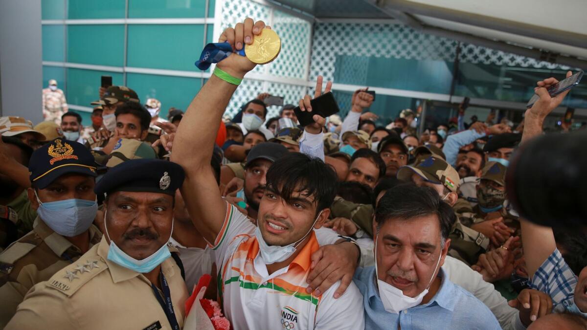 Olympic medallist Neeraj Chopra displays the gold medal he won in the men’s javelin at the Tokyo Games as he arrives at the Indira Gandhi International Airport in New Delhi. — AP