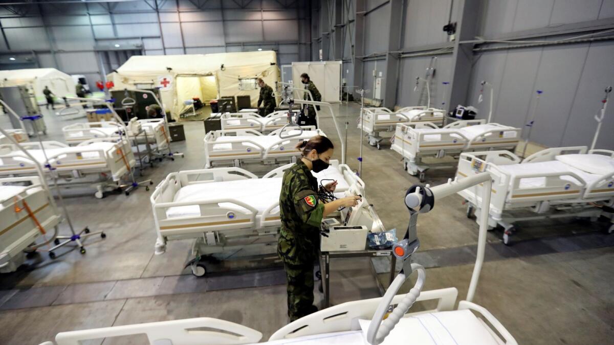 Members of the Czech Army set up beds inside of an exhibition centre to accommodate people who suffer mild symptoms of  coronavirus disease in Prague, Czech Republic, on Thursday.
