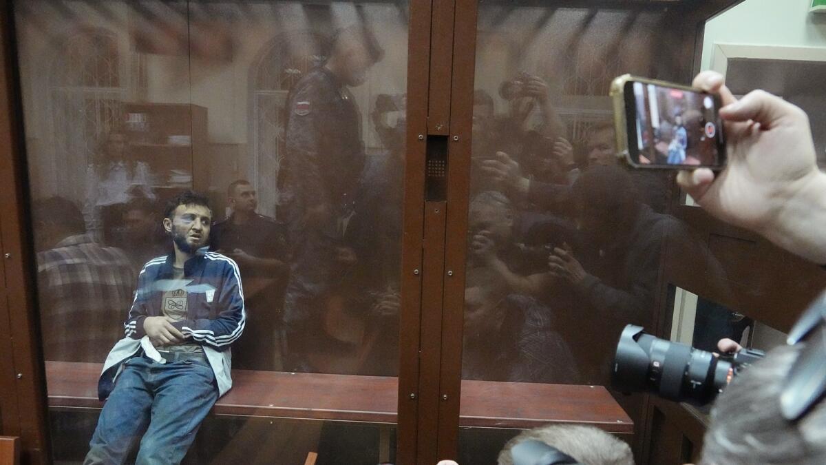 Dalerdzhon Mirzoyev, a suspect in the Crocus City Hall shooting on Friday sits in a glass cage in the Basmanny District Court in Moscow. — AP
