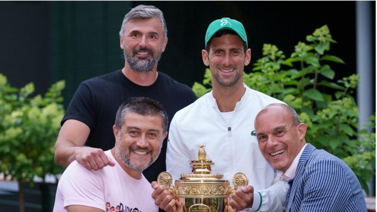 Novak Djokovic and his support staff pose with the trophy. (AFP)