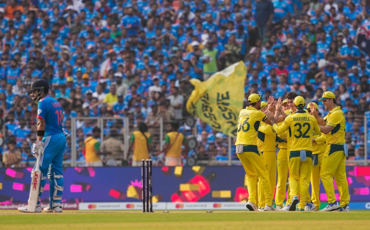 Australia's Pat Cummins with teammates celebrates the wicket of India's Virat Kohli (left) during the World Cup final. — PTI