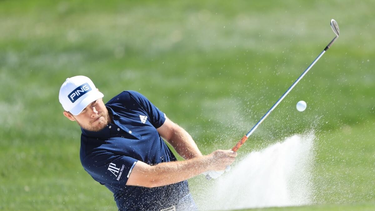 Tyrrell Hatton of England plays his third shot on the first hole
